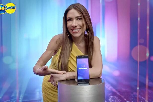 Patricia Abravanel em comercial da Tele Sena ao lado de um smartphone