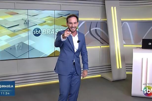 Daniel Adjuto aponta o dedo para a câmera no novo cenário do SBT Brasília