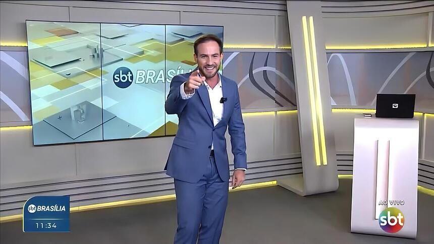 Daniel Adjuto aponta o dedo para a câmera no novo cenário do SBT Brasília