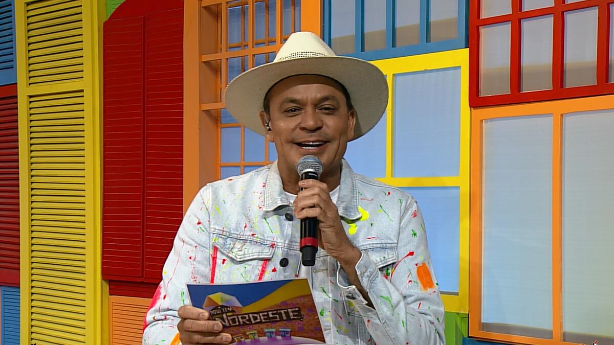 Frank Aguiar segura ficha e microfone na TV Aparecida