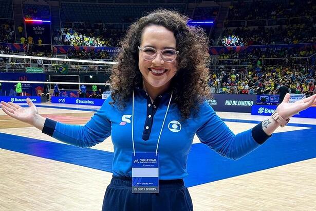 Natália Lara em foto posada em um ginásio de vôlei com o uniforme esportivo da Globo