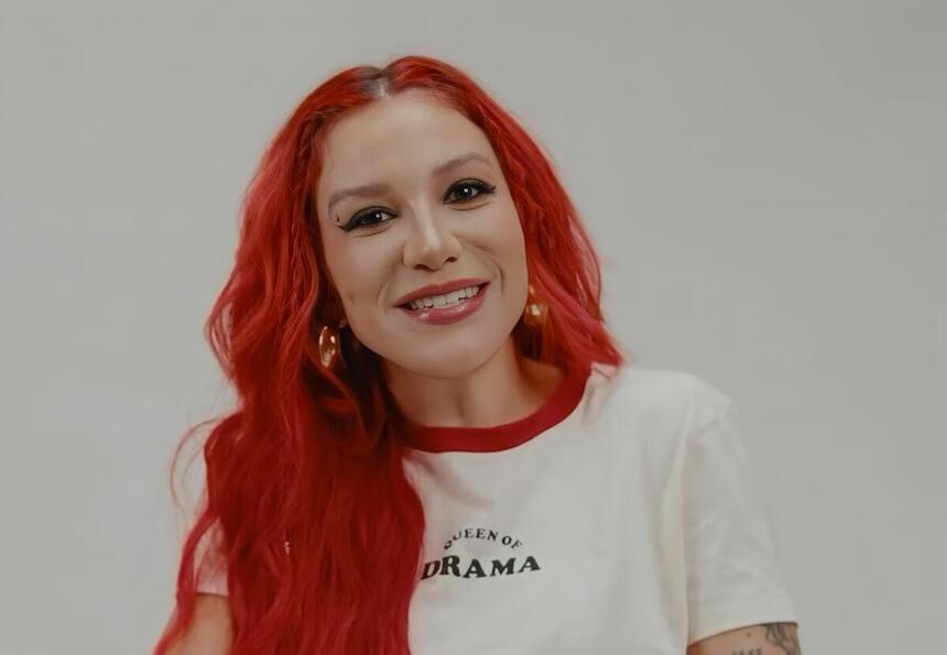 Priscilla de cabelo vermelho e sorrindo