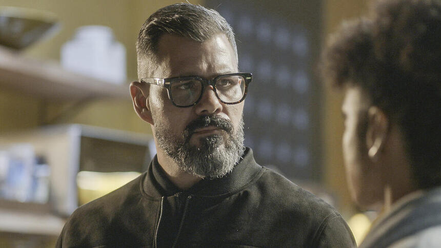 Juliano Cazarré com semblante sério em cena de novela na TV Globo