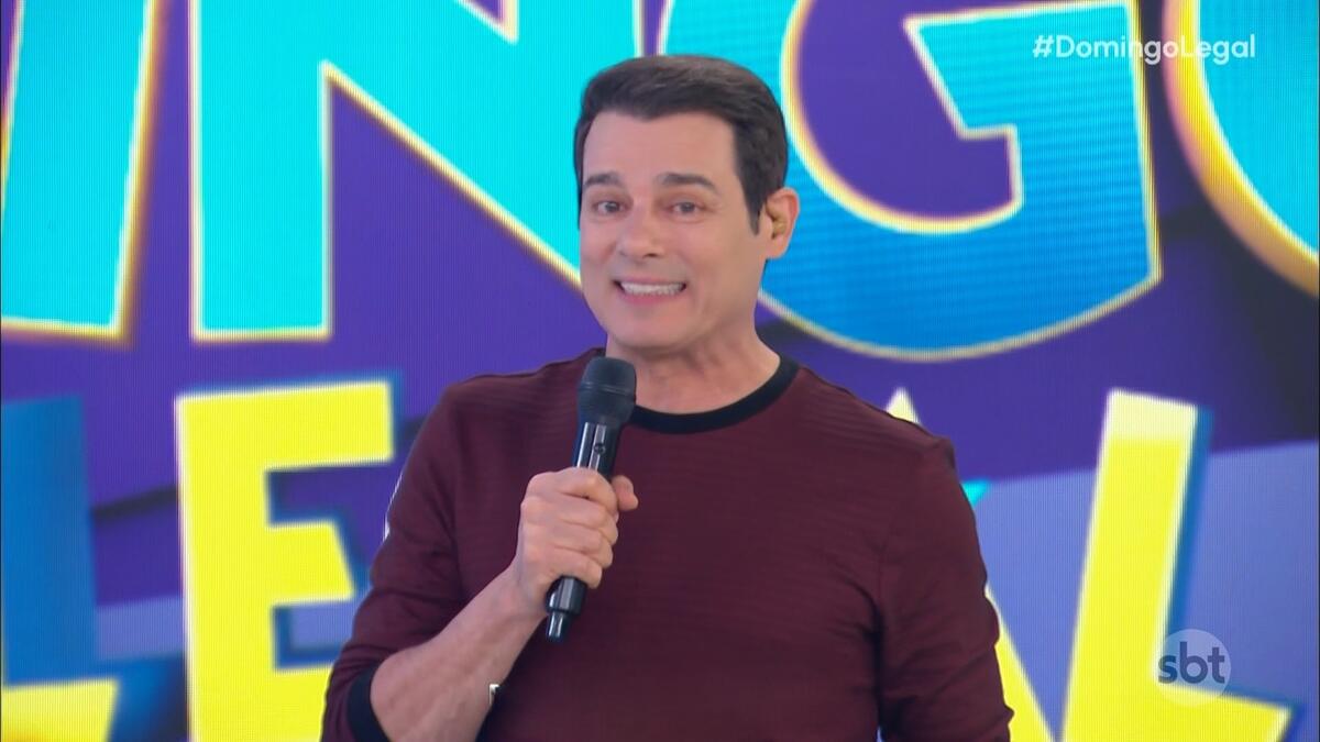 Celso Portiolli sorrindo no cenário do Domingo Legal