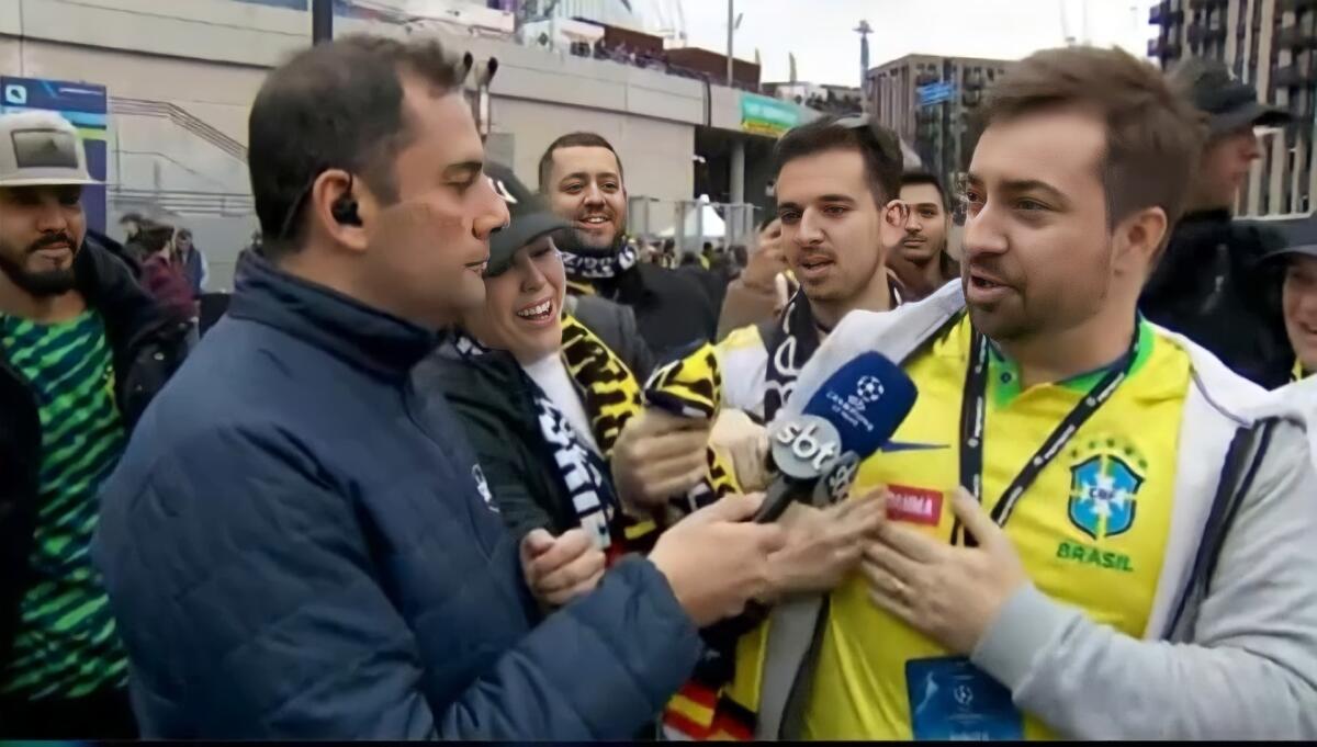 O repórter André Galvão entrevistando torcedores na porta do estádio de Wembley, em Londres