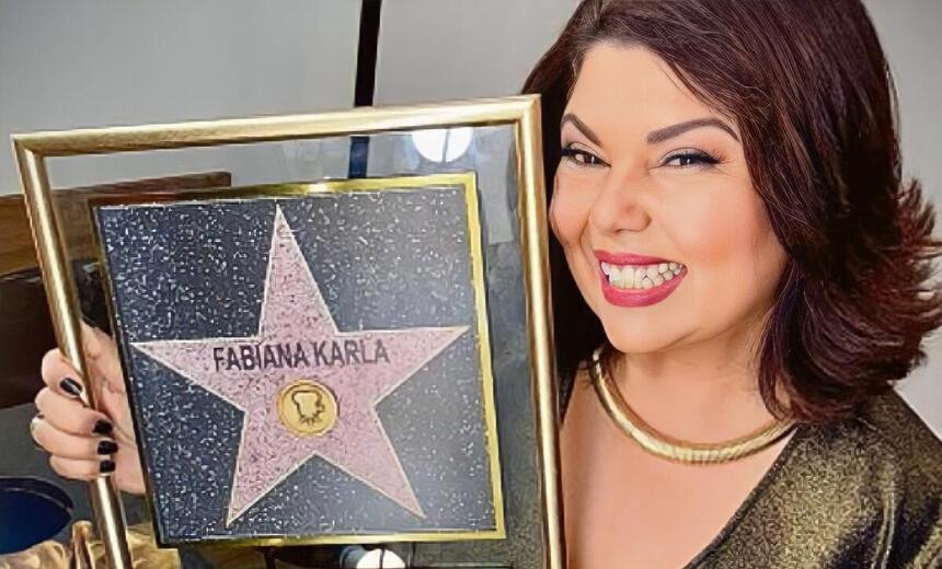 Fabiana Karla segura o quadro com a estrela na calçada da fama no SBT