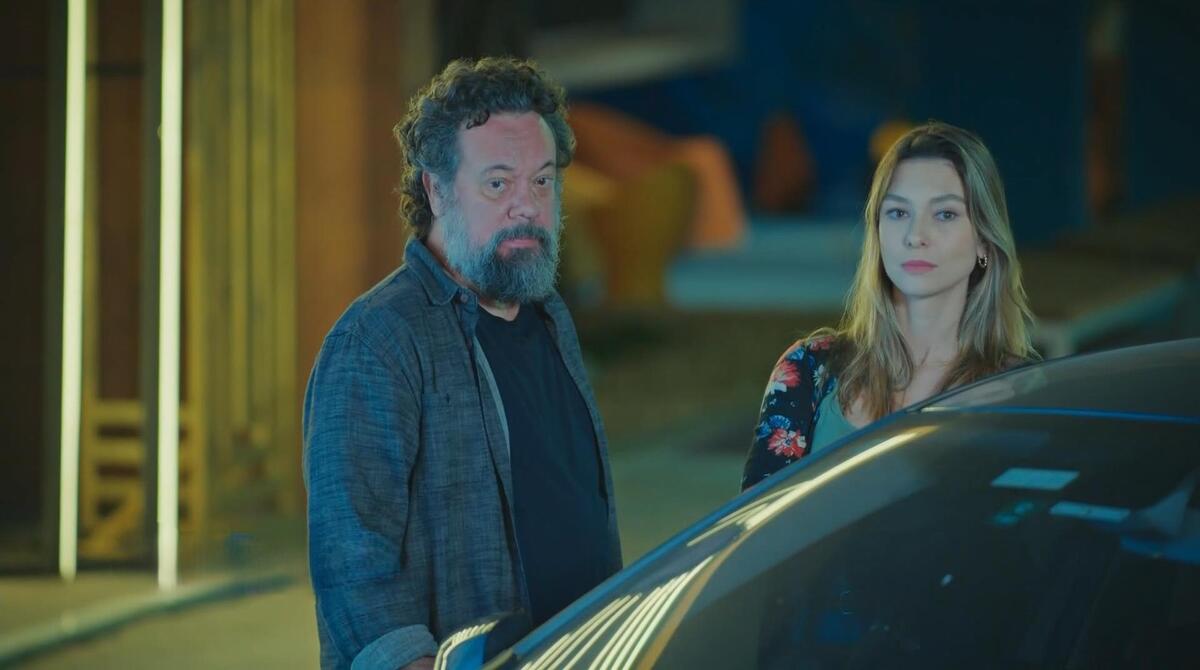 Otto e Marta próximo a um carro em uma noite, cena de Família é Tudo