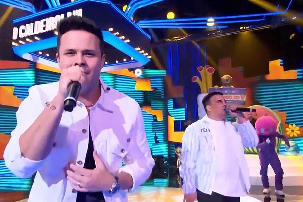 Matheus e Kauan cantando no palco do Caldeirão com Mion