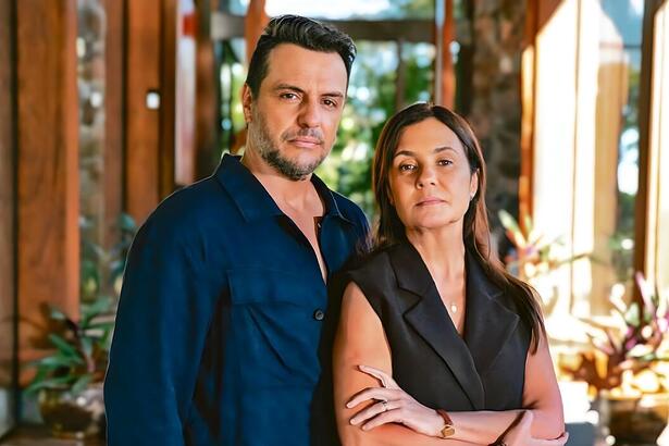 Molina (Rodrigo Lombardi) e Mércia (Adriana Esteves) abraçados em uma varanda em cena da novela Mania de Você