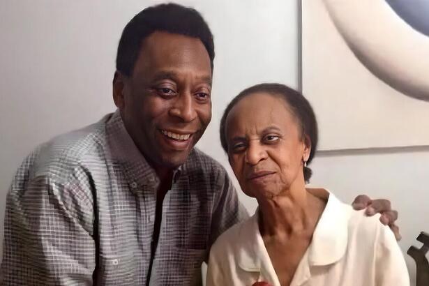 Mãe de Pelé ao lado do jogador segurano um bolo