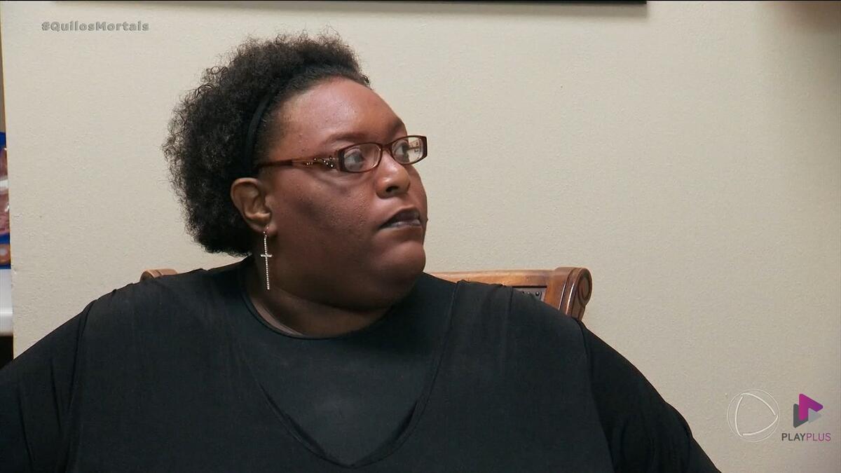 Tanisha de blusa preta em cena de Quilos Mortais