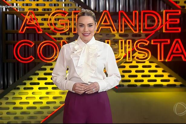 Rachel Sheherazade sorrindo no cenário do A Grande Conquista da RECORD