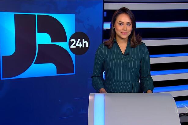 Salcy Lima sorrindo em frente ao telão do JR 24h, que venceu o SBT na audiência