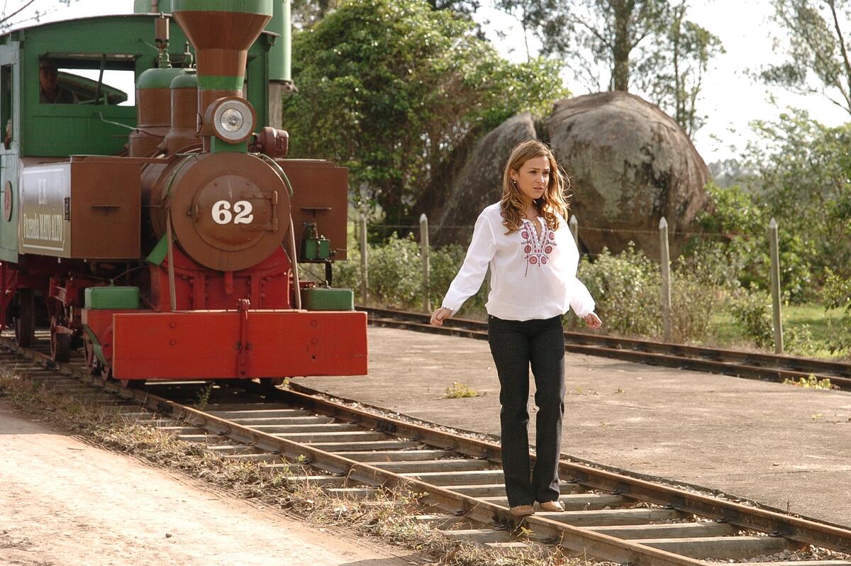 Simone andando na frente de um trem em cena de América no VIVA