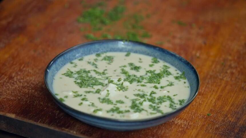 Sopa thai de peixe com leite de coco no prato do É de Casa