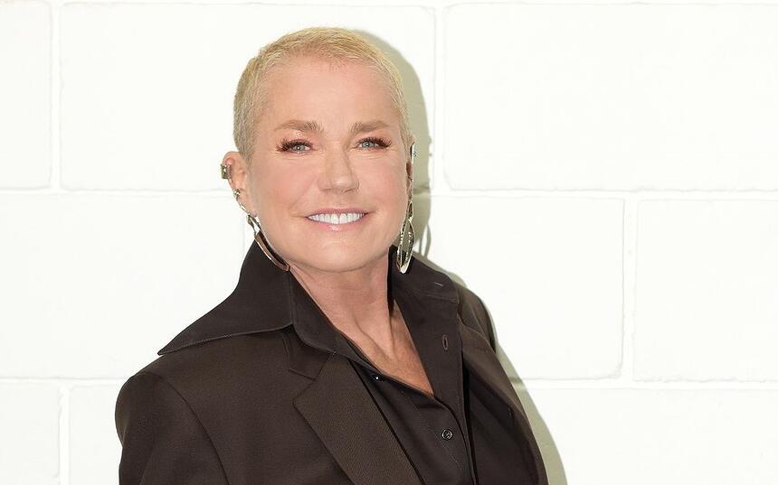 Xuxa de terno preto, sorrindo