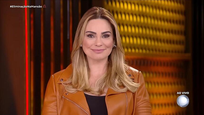 Rachel Sheherazade sorrindo enquanto apresenta a 11ª eliminação no A Grande Conquista 2