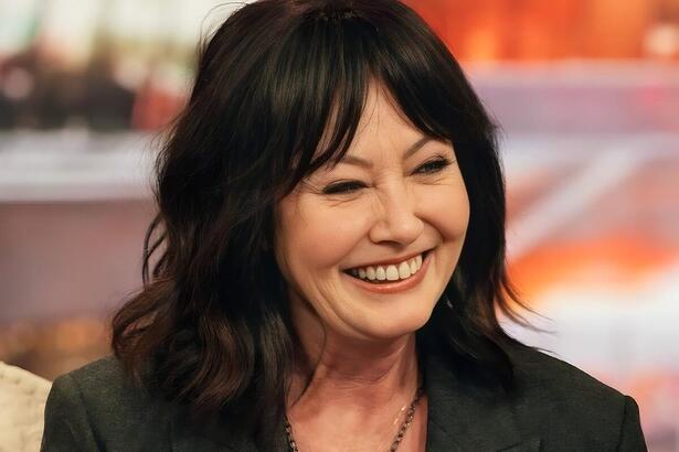 Shannen Doherty sorrindo em uma entrevista a um talk show