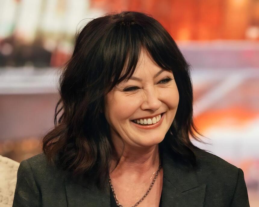 Shannen Doherty sorrindo em uma entrevista a um talk show