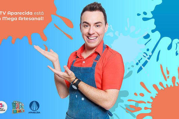 Apresentador posa com o banner promocional da feira