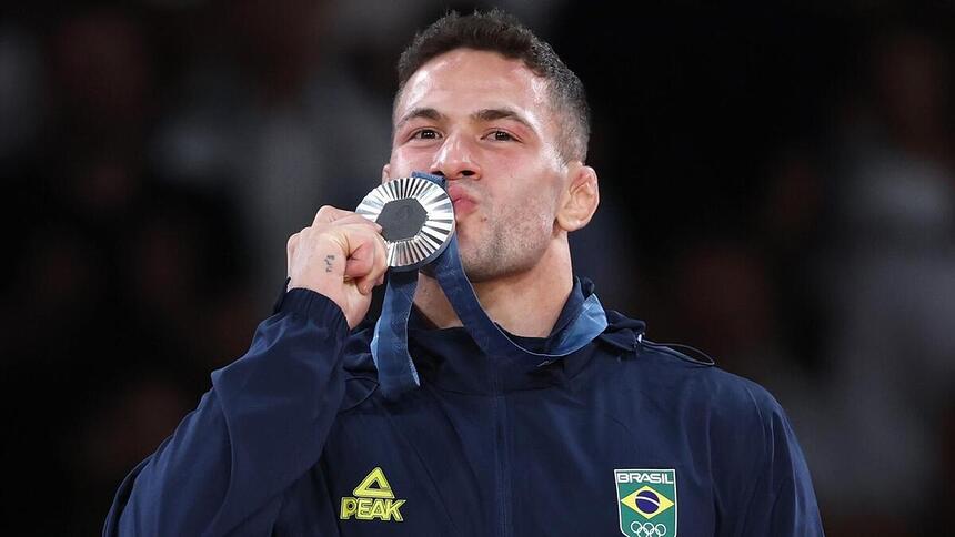 Willian Lima beijando a medalha conquista pelo judô na Olimpíada