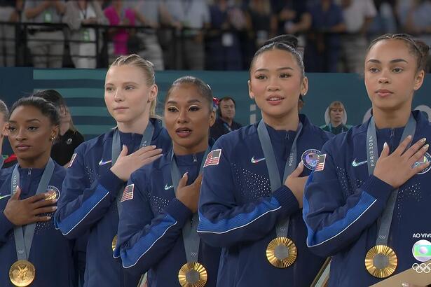 Simone Biles e as ginastas norte-americana com a mão no peito, segundo a medalha de ouro na Olimpíada de Paris 2024