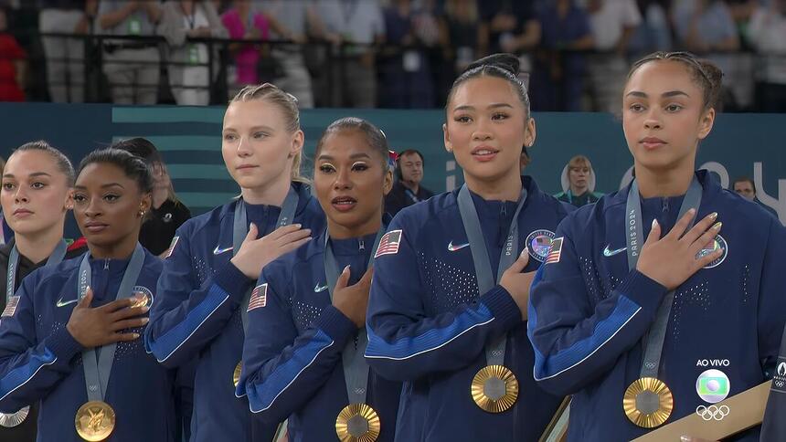 Simone Biles e as ginastas norte-americana com a mão no peito, segundo a medalha de ouro na Olimpíada de Paris 2024