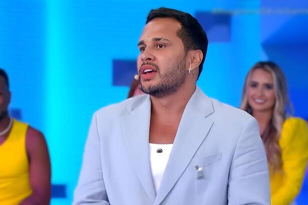 Lucas Guimarães no Programa Silvio Santos, vestindo terno azul em sua estreia no SBT