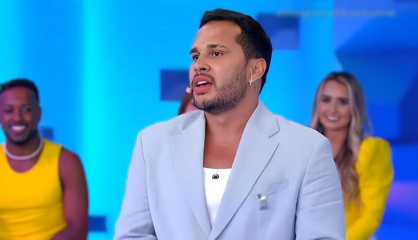 Lucas Guimarães no Programa Silvio Santos, vestindo terno azul em sua estreia no SBT