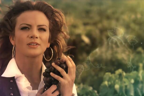 Silvia Navarro segura cacho de uvas na abertura da novela Quando Me Apaixono