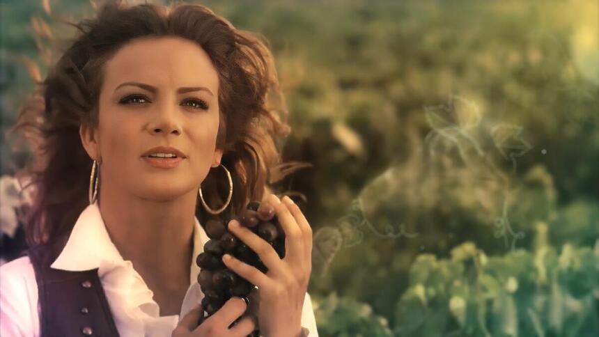 Silvia Navarro segura cacho de uvas na abertura da novela Quando Me Apaixono