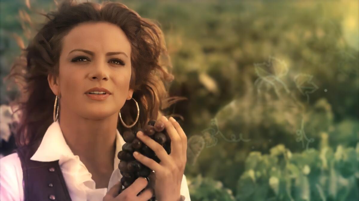 Silvia Navarro segura cacho de uvas na abertura da novela Quando Me Apaixono