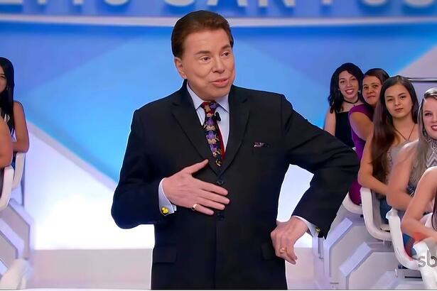 Silvio Santos no palco do SBT com a mão na brriga