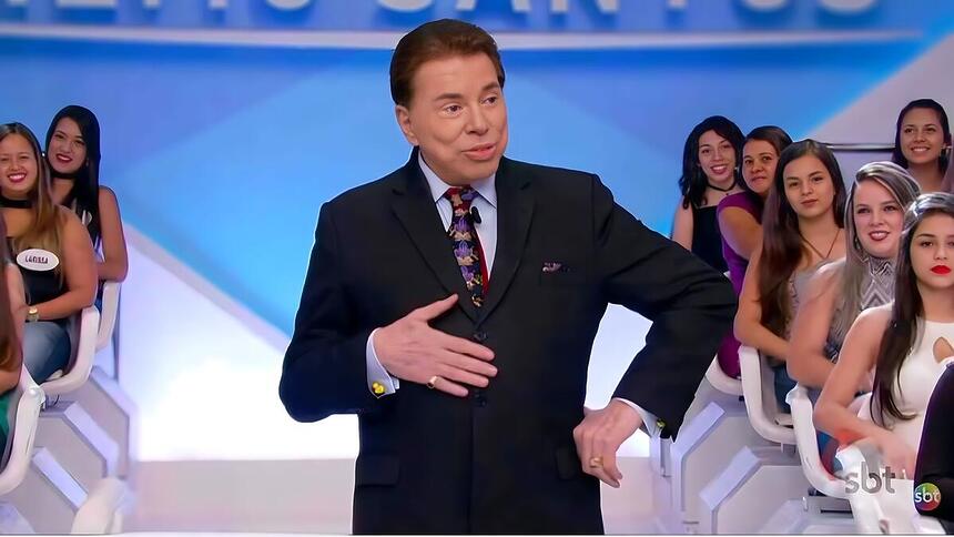 Silvio Santos no palco do SBT com a mão na brriga