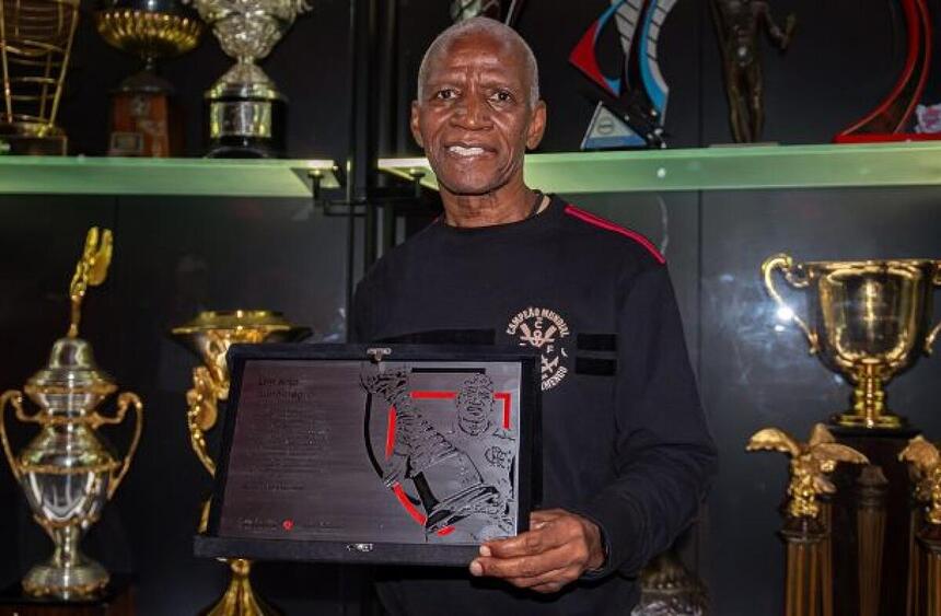 Adílio, segurando uma placa, em trecho de homenagem do Flamengo