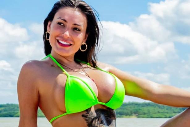 Andressa Urach de biquini verde, mostrando uma tatuagem