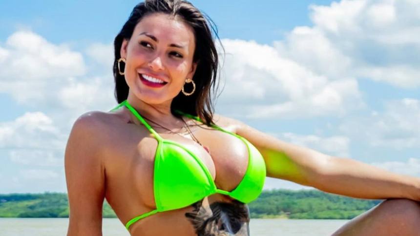 Andressa Urach de biquini verde, mostrando uma tatuagem