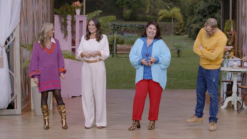 Fabiana Karla ao lado da jurada convidada Carol Fiorentino e dos jurados Carole Crema e André Mifano. Eles estão sorrindo no cenário do Bake Off Brasil