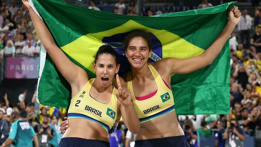 Duda e Ana Patrícia com a bandeira do Brasil na Olimpíada 2024, após conquista da medalha de ouro