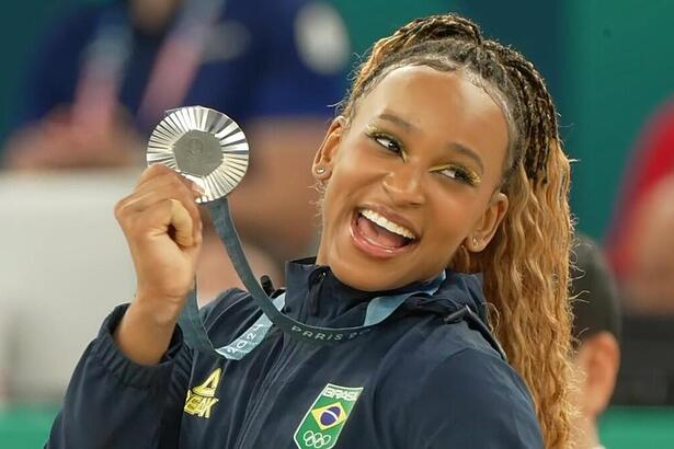 Rebeca Andrade sorrindo com a medalha de prata na Olimpíada na mão