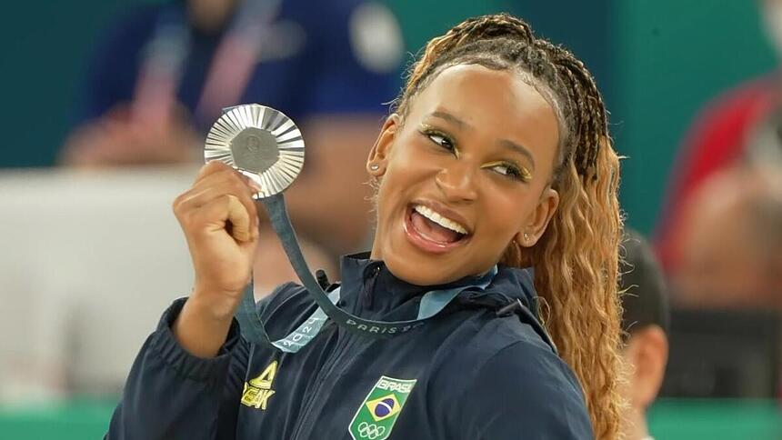 Rebeca Andrade sorrindo com a medalha de prata na Olimpíada na mão