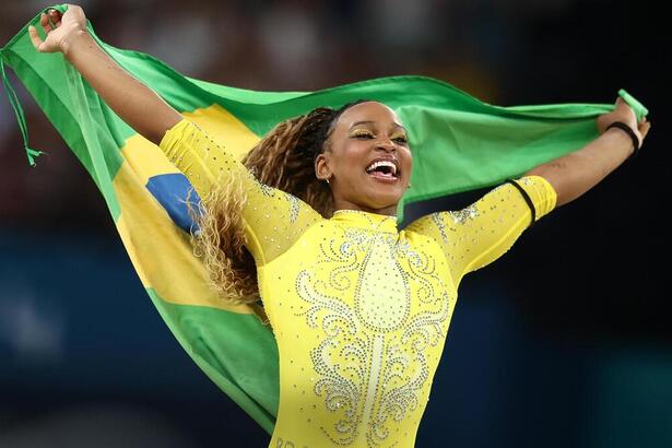 Rebeca Andrade carregando a bandeira do Brasil na Olimpíada