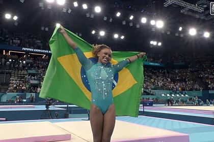 Rebeca Andrade com a bandeira do Brasil na Olimpíada