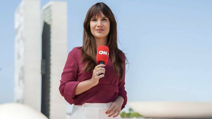 Renata Varandas segura microfone da CNN Brasil em frente a Câmara dos Deputados