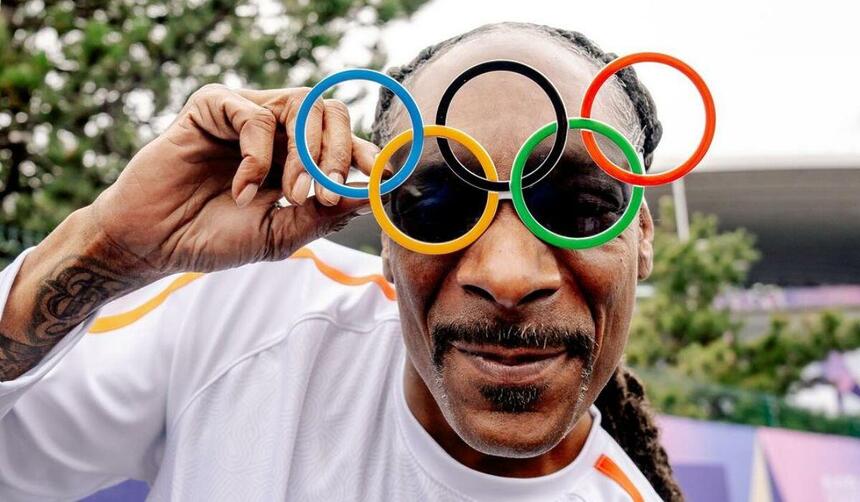 Snoop Dogg posando com um óculos com o arcos olímpicos na Olimpíada 2024