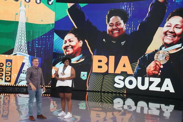 A judoca Beatriz Souza e Luciano Huck no centro do cenário do Domingão