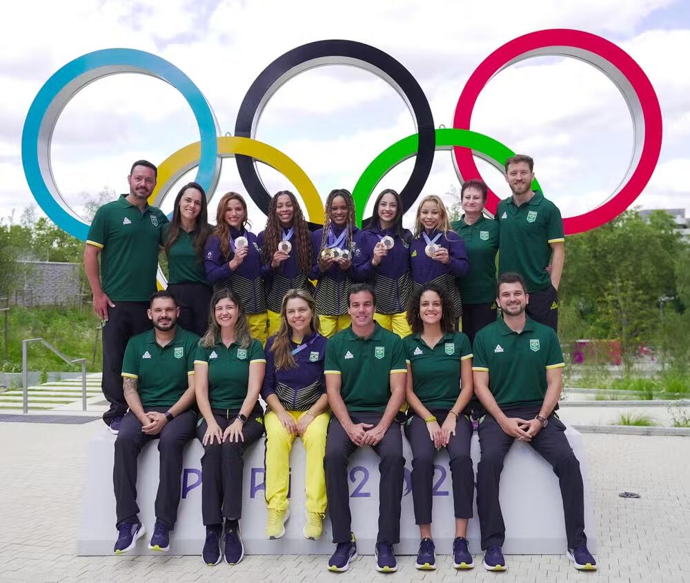 Ginastas brasileiras e equipe nos arcos olímpicos 