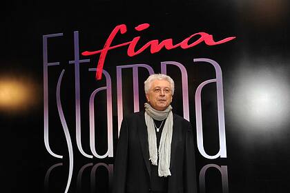 Aguinaldo Silva em frente a um banner com o logo da novela Fina Estampa, da TV Globo