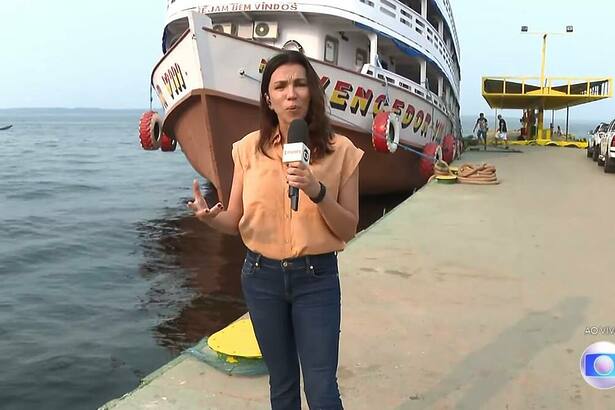 Ana Paula Araújo em frente a um barco, em trecho de edição do Bom Dia Brasil direto de Manaus