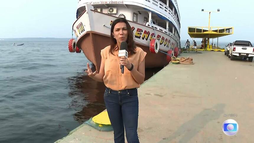 Ana Paula Araújo em frente a um barco, em trecho de edição do Bom Dia Brasil direto de Manaus